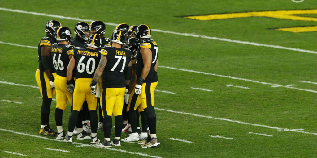 Pittsburgh Steelers center J.C. Hassenauer (#60) huddles up