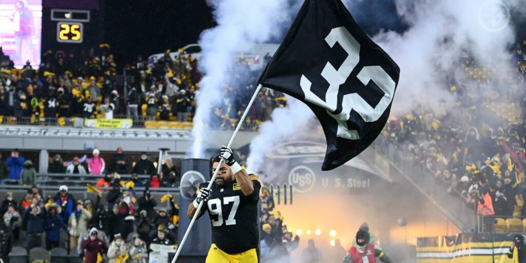 Cameron Heyward of the Pittsburgh Steelers carries a flag honoring Franco Harris