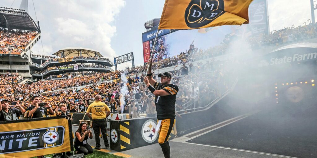 Pittsburgh Steelers quarterback Ben Roethlisberger (7) waves a DMR flag in honor of the late Dan Rooney